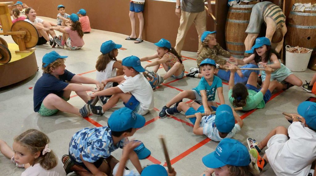 Niños del campamento rías altas de a coruña juegan a un juego tradicional en el museo melga