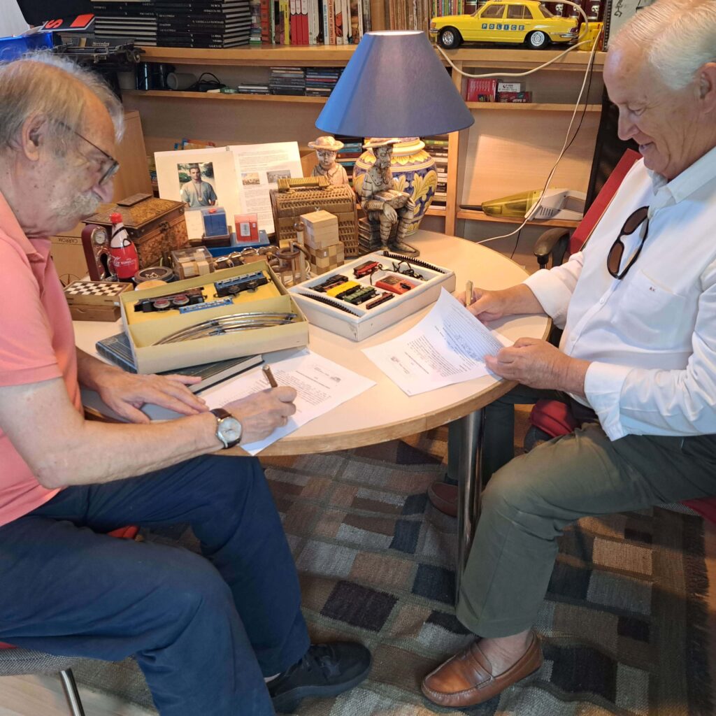 Ricardo Pérez y Verdes firmando un documento con un compañero