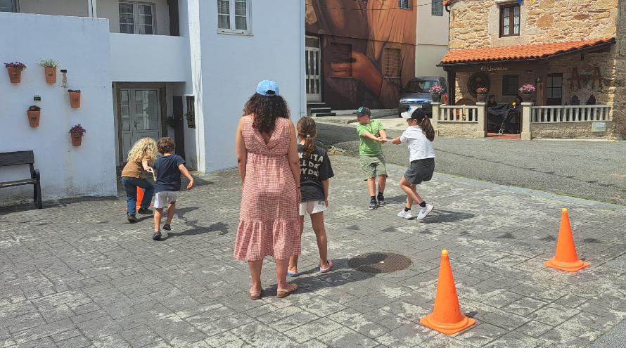 Varios nenos e unha monitora xogando na plaza do outeirño na edición do festiletras 2025